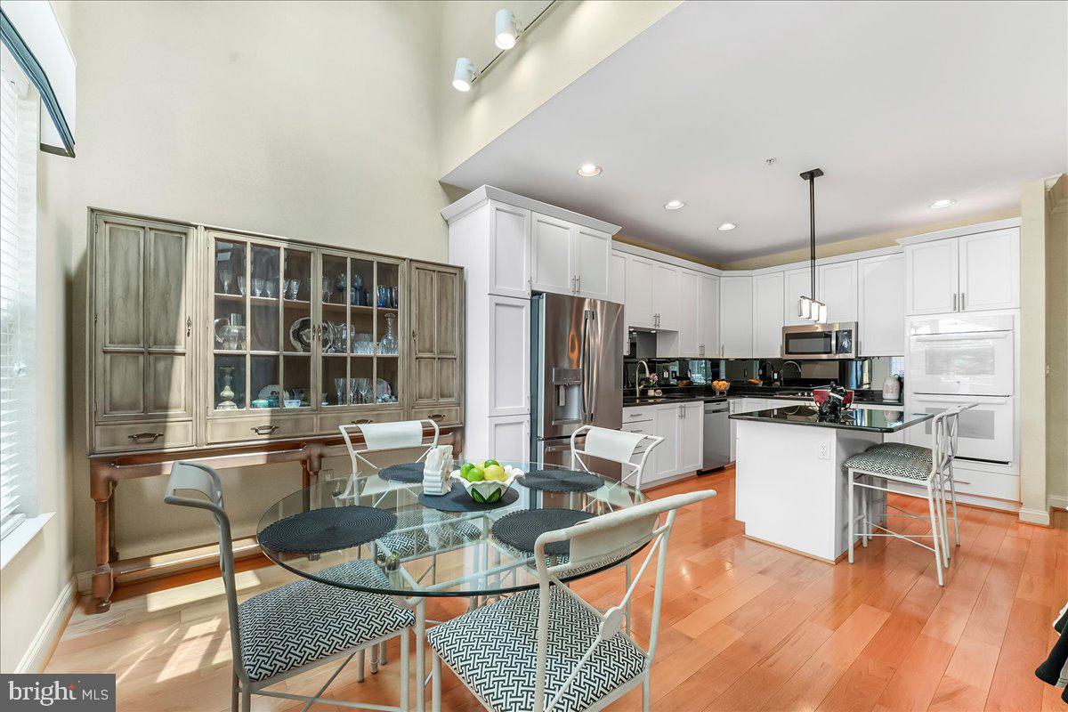 1132 Brian's Way Wayne, PA 19087 - Photo 14 of 45 a kitchen with stainless steel appliances kitchen island granite countertop a dining table chairs and refrigerator