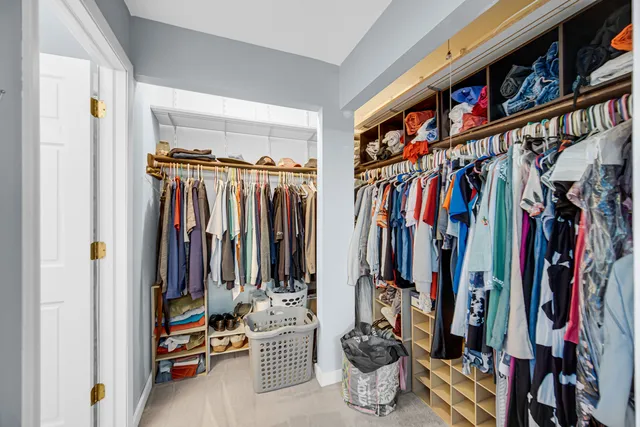 a view of walk in closet with clothes and shoes