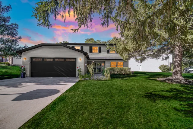 a front view of a house with a garden and yard