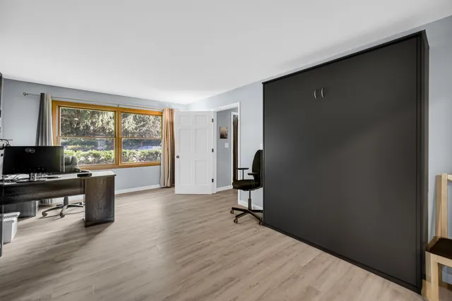 a view of a livingroom with workspace and a window