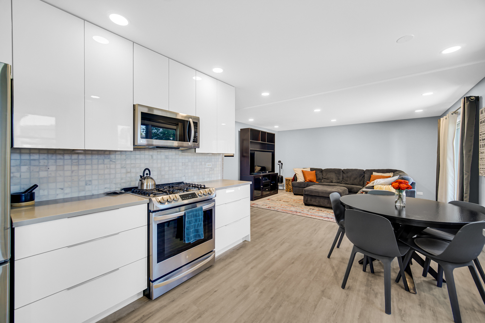 1028 West Park Pl Drive Bartlett, IL 60103 - Photo 6 of 24 a kitchen with furniture wooden floor and stainless steel appliances