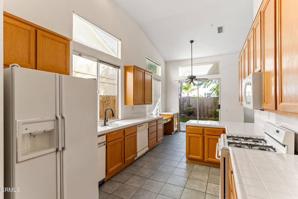 408 Grande Street Oxnard, CA 93036 - Photo 19 of 45 a kitchen with stainless steel appliances a refrigerator a sink and white cabinets