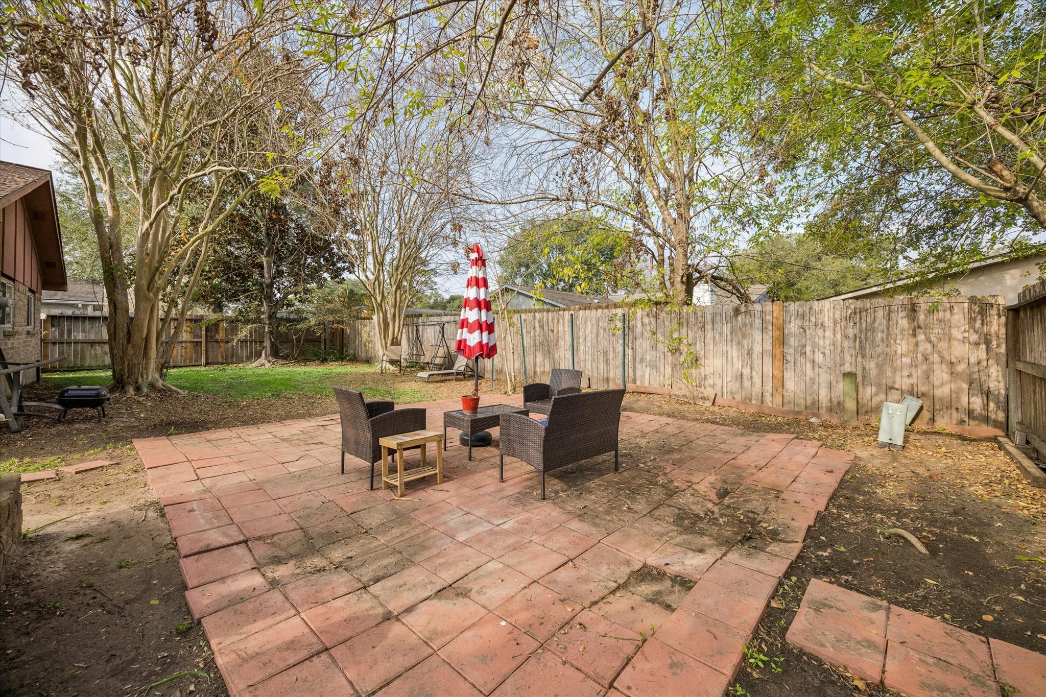 3902 Broken Elm Drive Spring, TX 77388 - Photo 18 of 19 a view of a backyard with table and chairs and a barbeque with potted plants and large trees