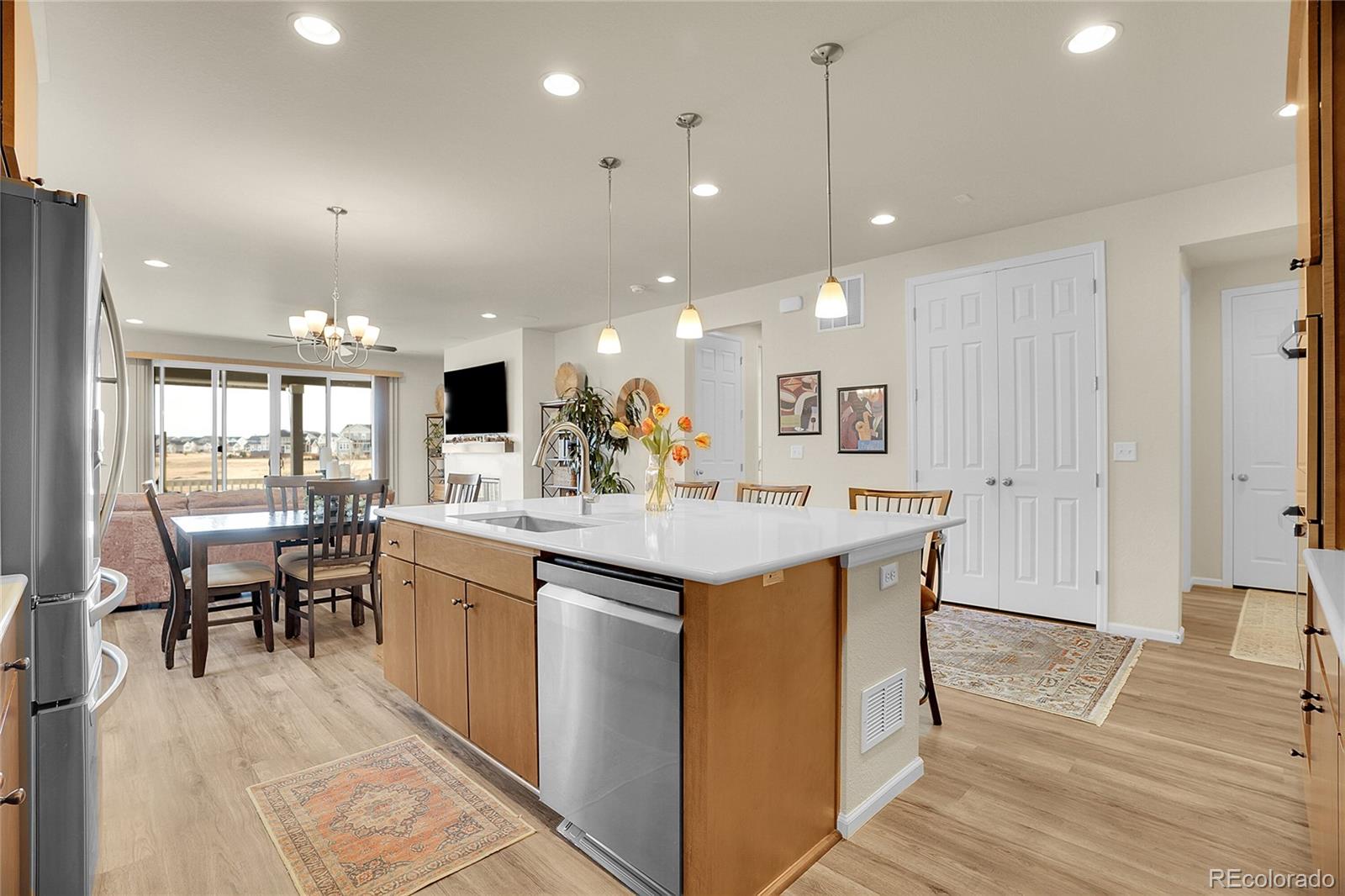 815 Bear Peak Road Erie, CO 80516 - Photo 10 of 32 a large kitchen with kitchen island a sink a counter space dining table and chairs