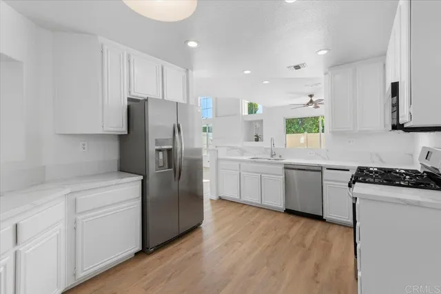 a kitchen with white cabinets and stainless steel appliances