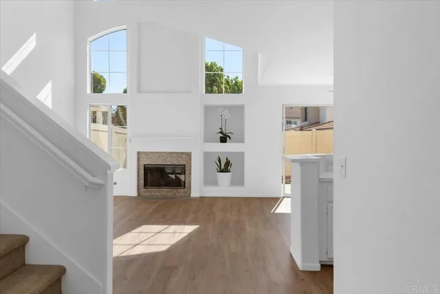 a view of a livingroom with wooden floor and a fireplace