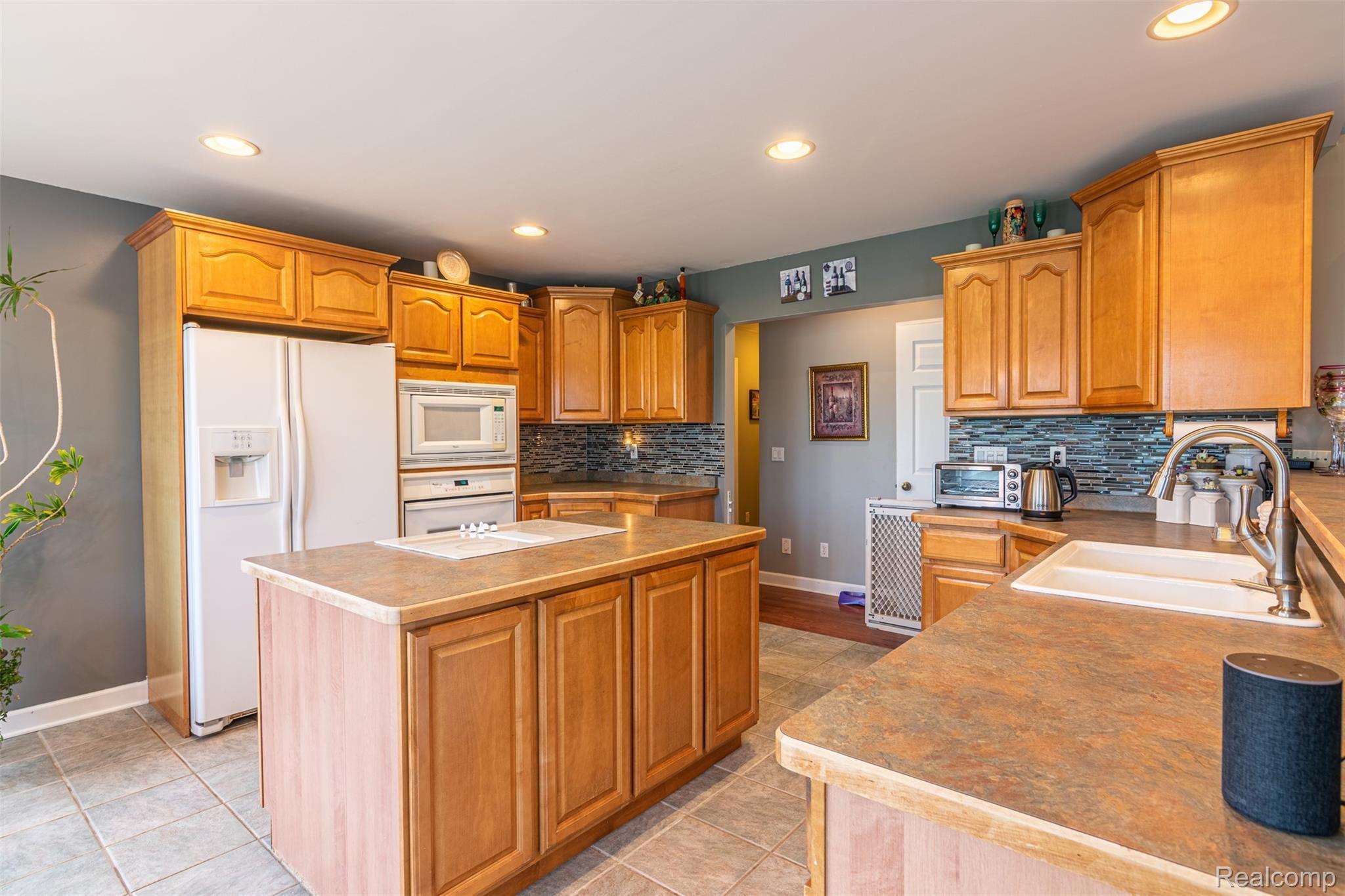 10151 Meskill Road Columbus, MI 48063 - Photo 7 of 39 Open-concept kitchen with a large kitchen island, built-in central vac sweepers, and a breakfast bar!