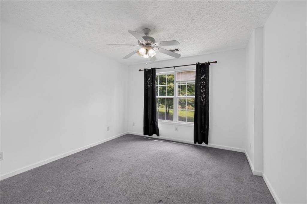 602 Pendergrass Road Winder, GA 30680 - Photo 30 of 44 an empty room with chandelier fan and windows