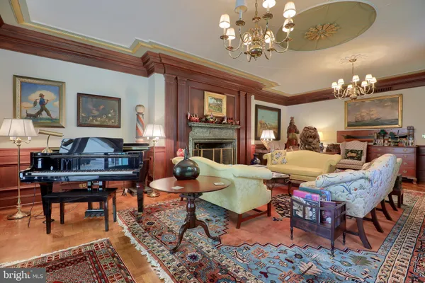 a living room with fireplace furniture and a chandelier
