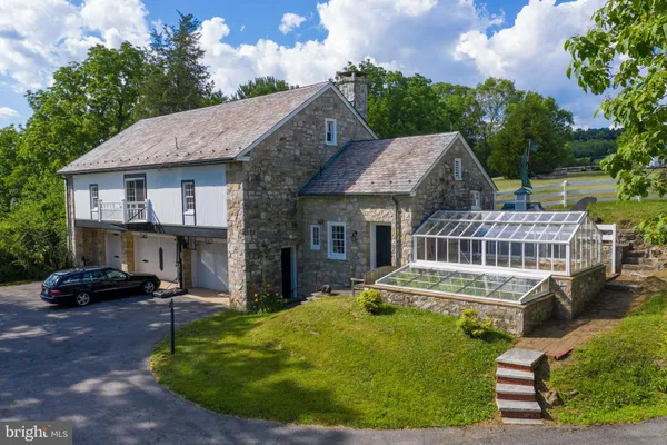 a front view of a house with a garden and trees