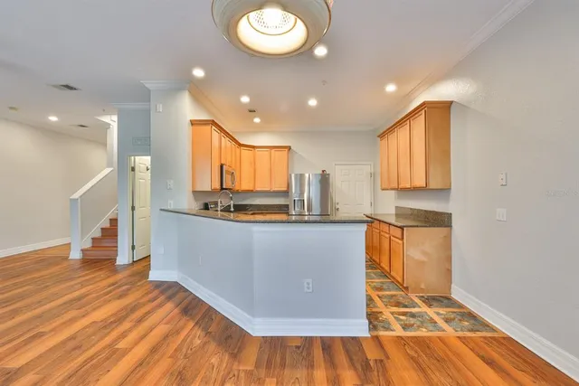 a large kitchen with stainless steel appliances granite countertop a sink and a stove top oven