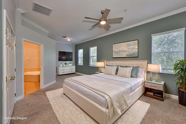 a spacious bedroom with a large bed a chandelier and closet