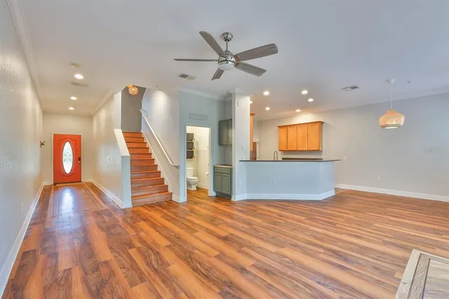 a view of a livingroom with wooden floor and a ceiling fan
