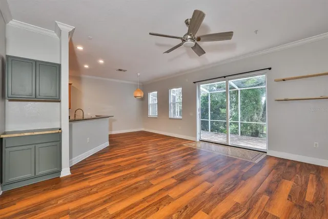 a view of an empty room with window and wooden floor