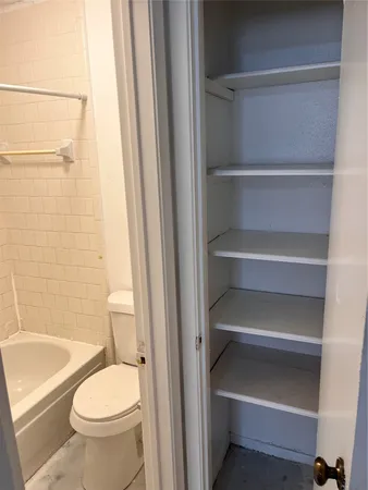 a white toilet sitting next to a bath tub