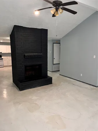 a living room with stainless steel appliances kitchen island granite countertop furniture and a ceiling fan