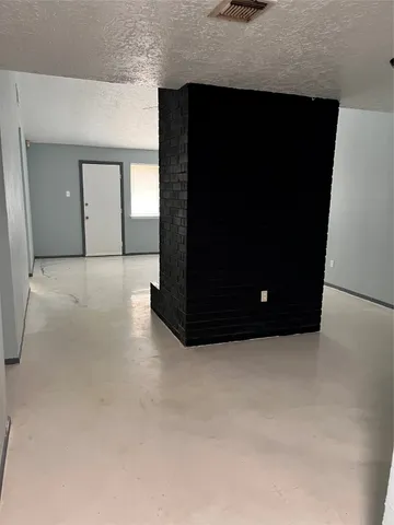 a living room with a black wall and a refrigerator