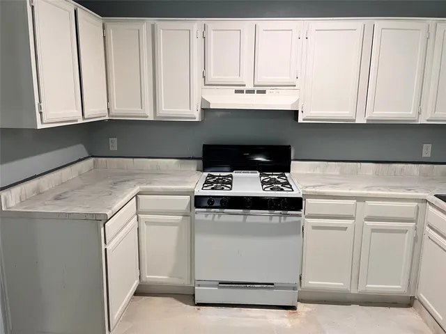 a kitchen with white cabinets and white appliances