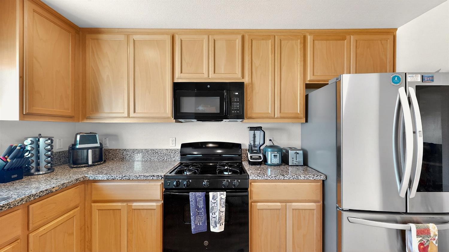 753 Taryn Court Merced, CA 95341 - Photo 5 of 21 a kitchen with stainless steel appliances granite countertop a refrigerator a stove a sink and white cabinets