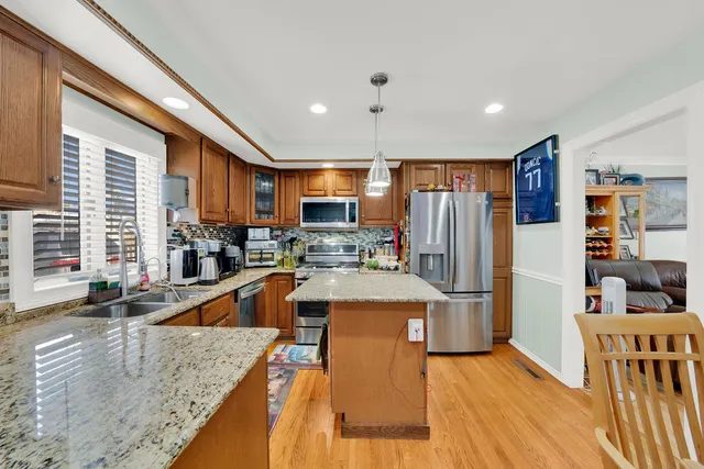 a kitchen with stainless steel appliances granite countertop a refrigerator a stove and a sink