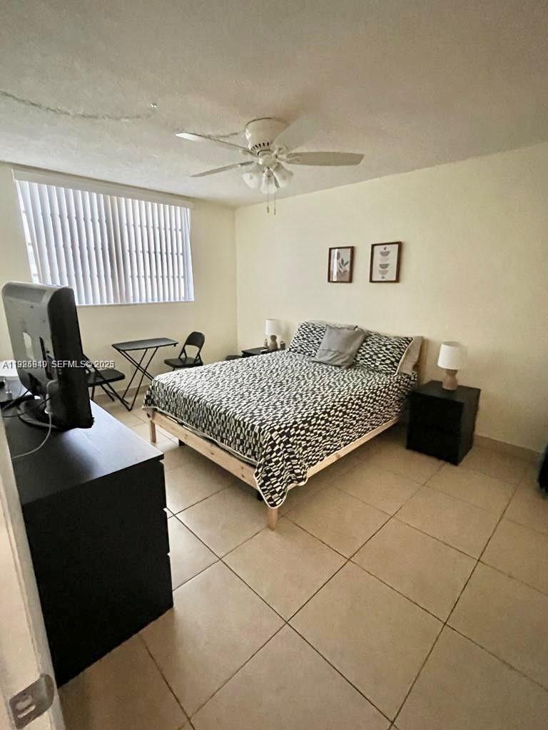 5961 Northwest 61st Avenue, Unit 208 Tamarac, FL 33319 - Photo 7 of 11 a bedroom with a bed and a desk