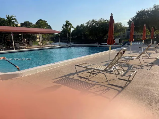 a view of a swimming pool with a patio and a yard