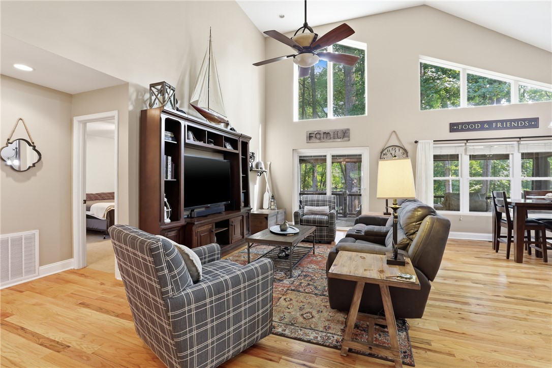 1110 Sunset Lane Anderson, SC 29626 - Photo 4 of 38 A spacious living area features lofty ceilings, a cozy fireplace, and abundant natural light filtering through tall windows.