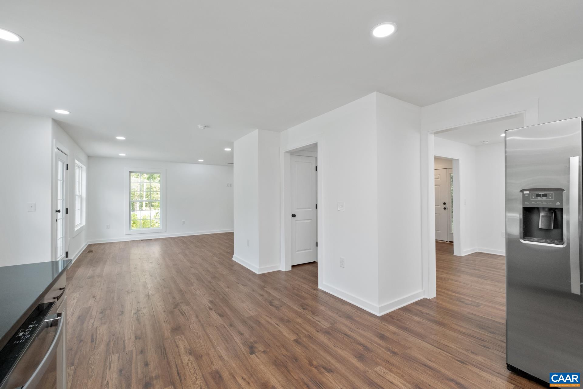 2211 Carpenters Mill Road Ruckersville, VA 22968 - Photo 18 of 25 a view of empty room with wooden floor and kitchen