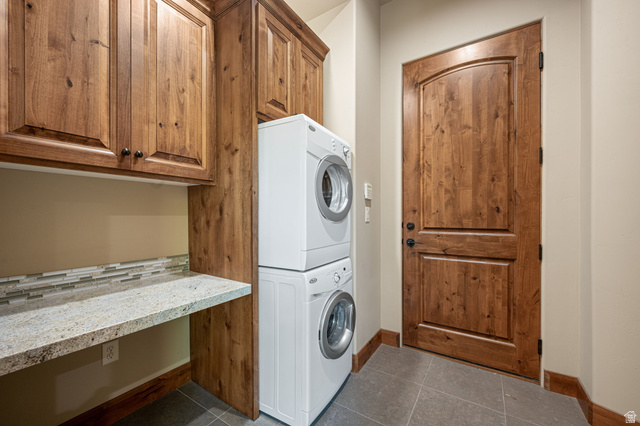 2331 West Entrada Trail, Unit 61 St. George, UT 84770 - Photo 52 of 69 Utility space featuring wood-finish cabinetry with black hardware, a light-toned countertop, and a mosaic tile backsplash
