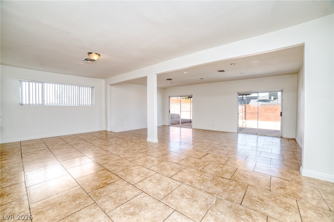3556 Ruth Drive Las Vegas, NV 89121 - Photo 5 of 21 A spacious, open concept living area boasts elegant tile flooring and ample natural light from large windows and sliding glass doors.