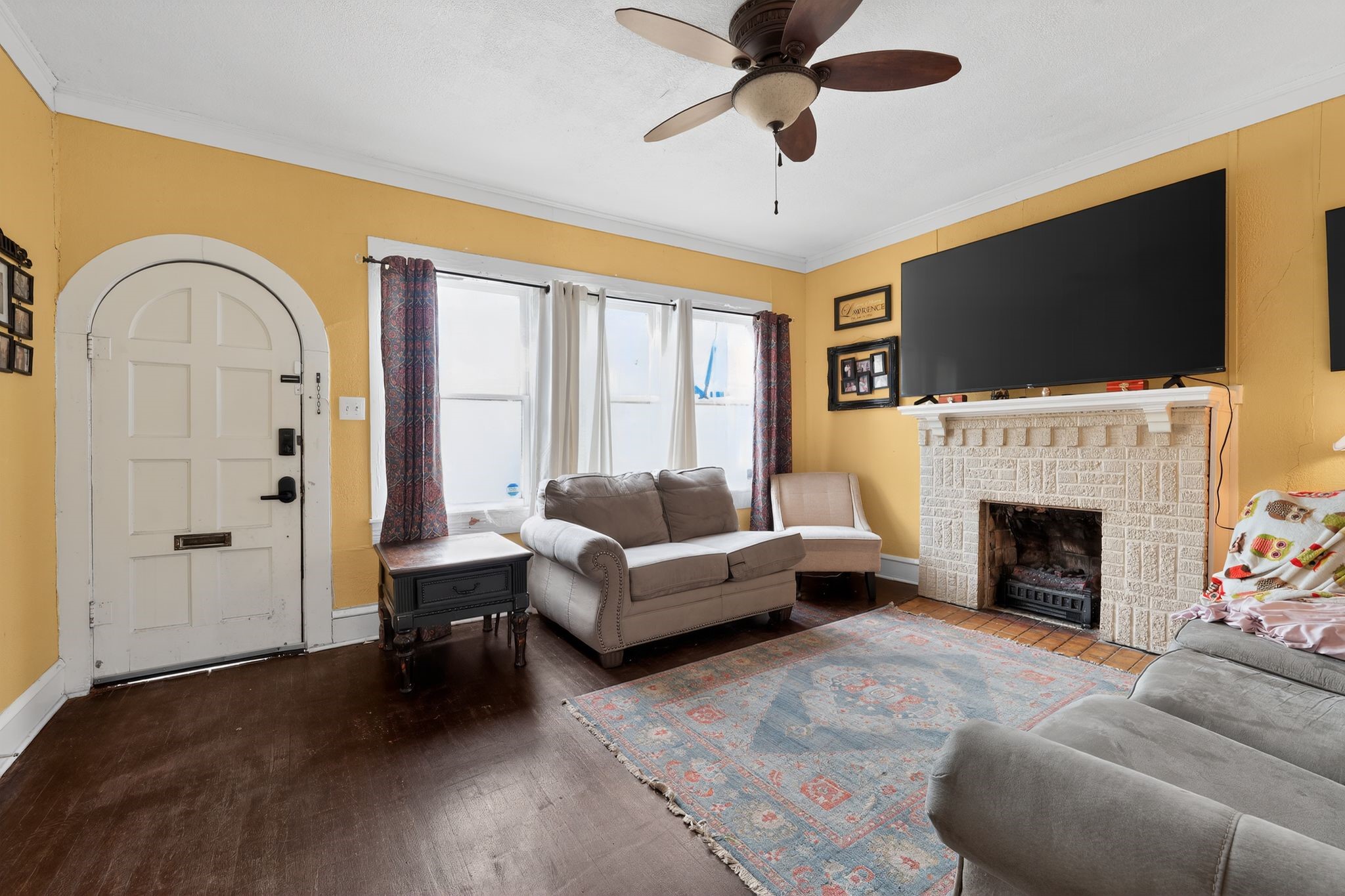 1017 North 11th Street Temple, TX 76501 - Photo 9 of 25 a living room with furniture a fireplace and a flat screen tv