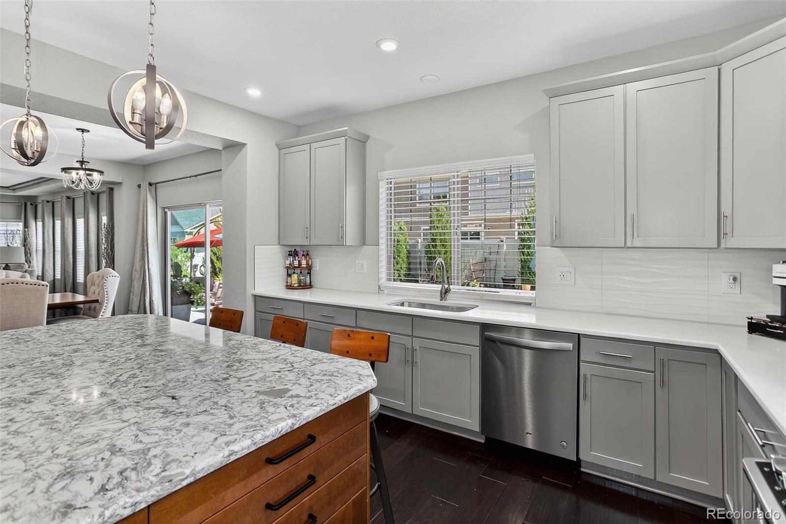 5012 Liverpool Street Denver, CO 80249 - Photo 12 of 49 a kitchen with stainless steel appliances granite countertop a sink a stove and a wooden floors