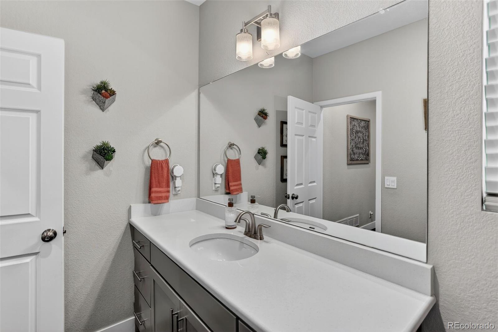 5012 Liverpool Street Denver, CO 80249 - Photo 18 of 49 a bathroom with a sink and a mirror