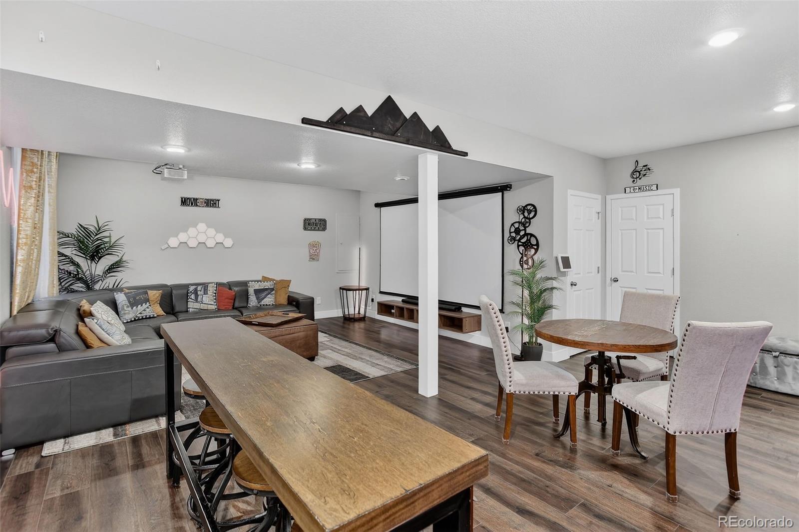 5012 Liverpool Street Denver, CO 80249 - Photo 32 of 49 a living room with furniture a wooden floor and a chandelier