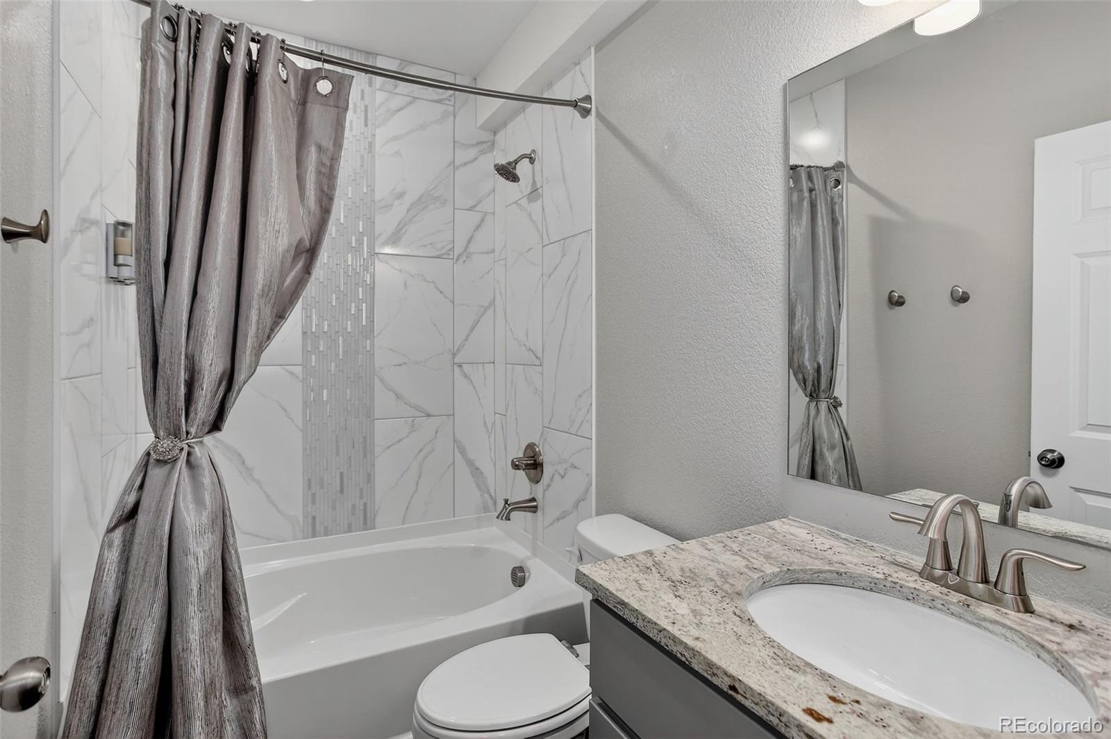 5012 Liverpool Street Denver, CO 80249 - Photo 35 of 49 a bathroom with a granite countertop sink toilet and shower