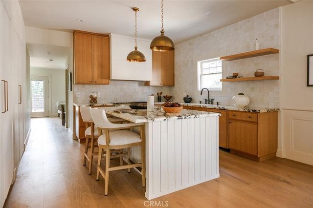 a view of a dining room and livingroom with furniture wooden floor a chandelier