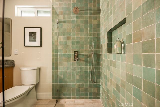 a bathroom with a granite countertop toilet a sink a mirror and shower