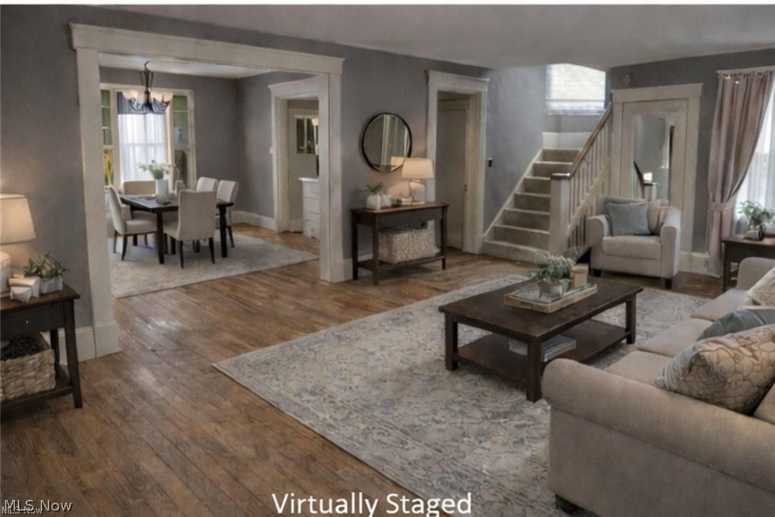 1911 Youngstown Road Southeast Warren, OH 44484 - Photo 3 of 17 Living room featuring plenty of natural light, hardwood / wood-style flooring, stairway, and a chandelier