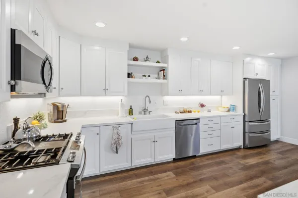 a large kitchen with a stove top oven and white cabinets