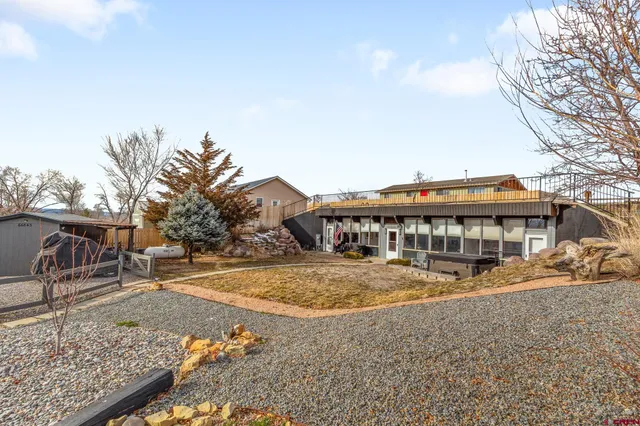 a view of a white house with a yard and sitting area