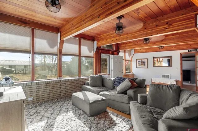 a living room with furniture and a floor to ceiling window