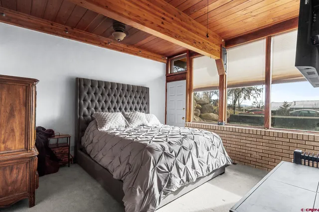 a large bed sitting in a bedroom next to a window