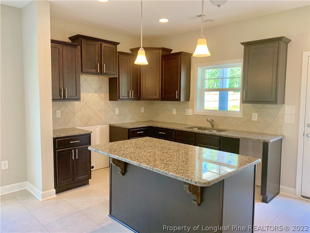 939 Montrose Road Raeford, NC 28376 - Photo 8 of 25 a kitchen with stainless steel appliances granite countertop a sink a stove and a refrigerator