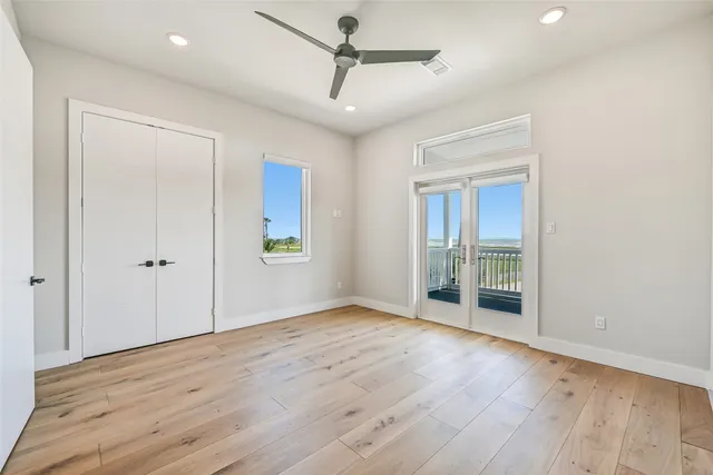 a view of empty room with wooden floor and ceiling fan