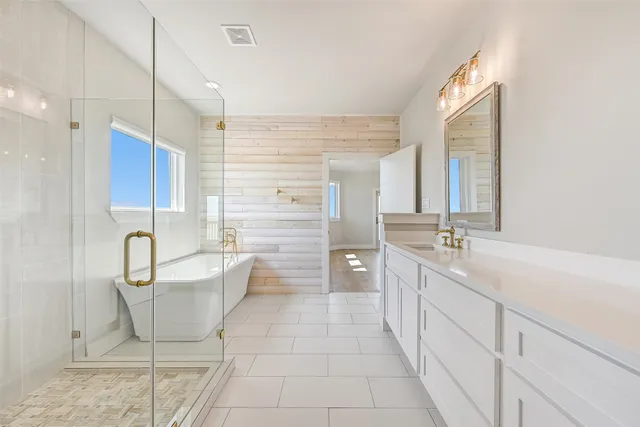 a spacious bathroom with a double vanity sink a mirror and a bathtub