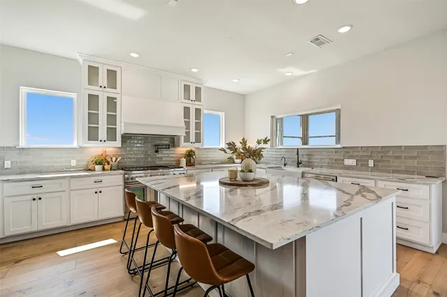 a kitchen with stainless steel appliances granite countertop a stove and a refrigerator