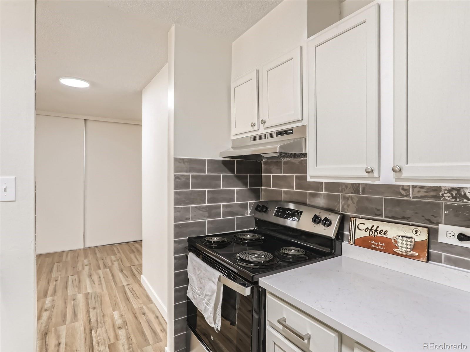 2281 South Vaughn Way, Unit 214A Aurora, CO 80014 - Photo 1 of 26 a kitchen with granite countertop a stove and a sink