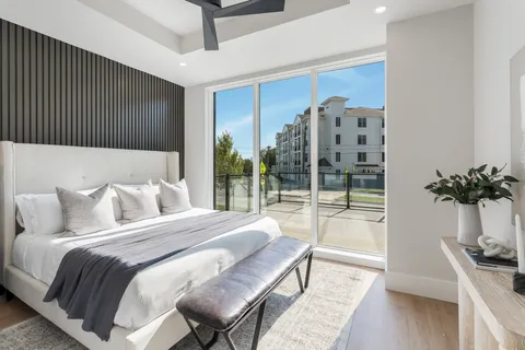 a bedroom with a large bed and a potted plant