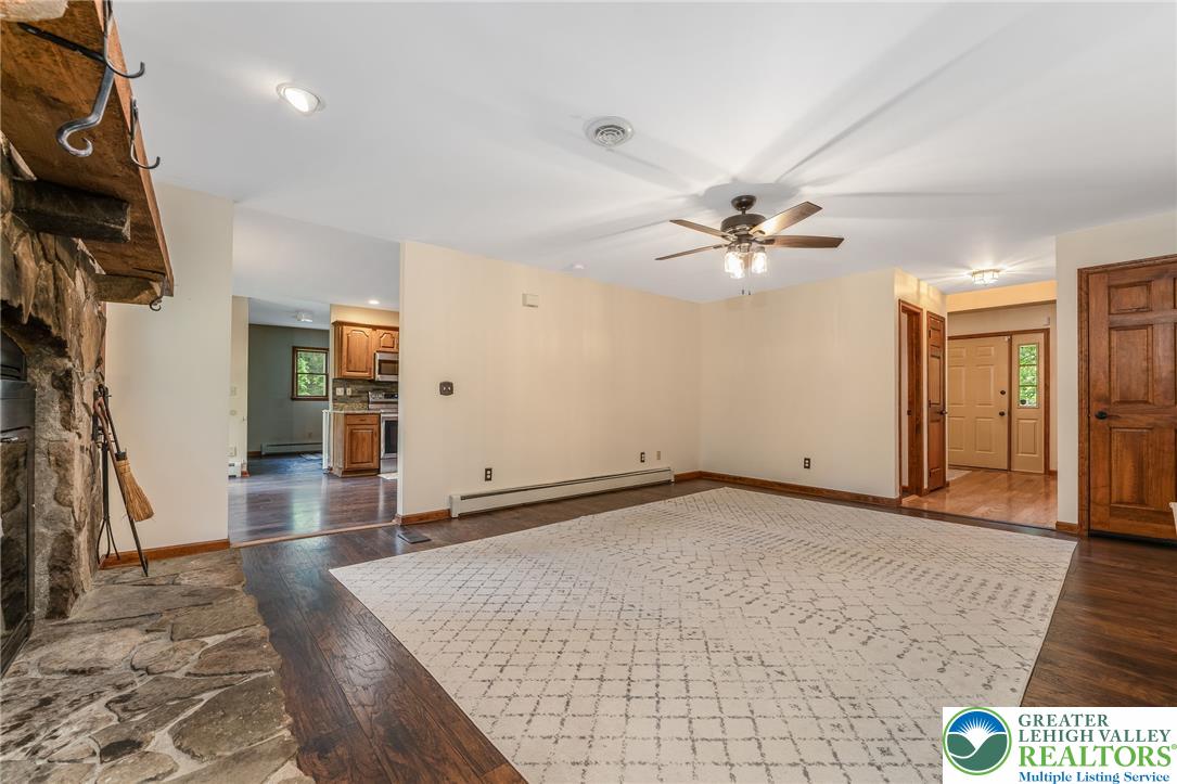 465 Raubsville Road Easton, PA 18042 - Photo 25 of 60 A welcoming living space flows into the kitchen and foyer, offering Laminate flooring and a stone fireplace hearth.