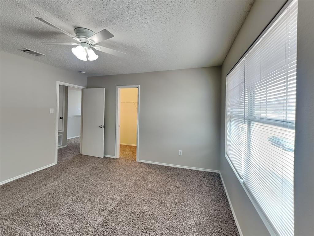 216 Turning Tree Road Wilmer, TX 75172 - Photo 11 of 20 Unfurnished bedroom with a walk in closet, carpet floors, a textured ceiling, and ceiling fan